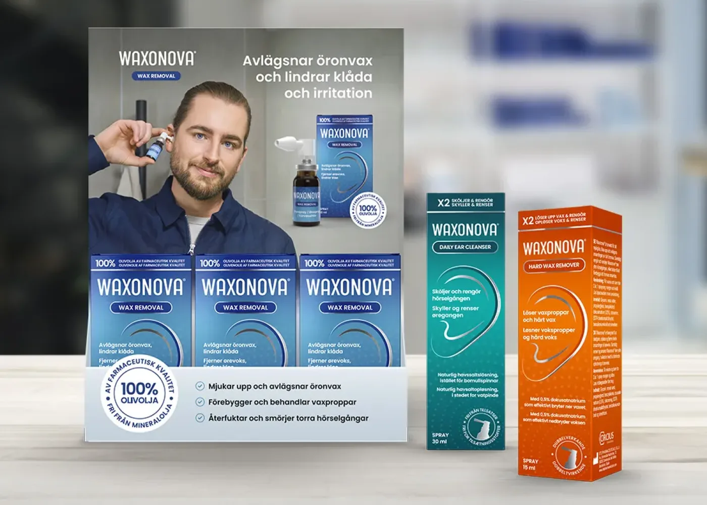 En man använder Waxonova öronvaxborttagare, som visas med produktlådor och flaskor. Text på svenska lyfter fram fördelarna med att avlägsna öronvax och lindra irritation. En andra orange produktförpackning syns också till höger.